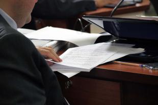 #PraCegoVer: Foto mostra detalhe da mão de um vereador folheando um documento.