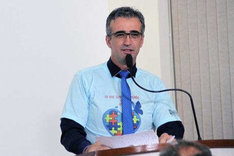 #PraCegoVer: Foto do vereador Edson Secafim na tribuna da Câmara, discursando para os demais vereadores e para o público. Ele usa uma camiseta alusiva ao Dia Mundial da Conscientização do Autismo.