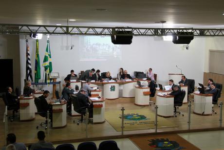 #PraCegoVer:  Foto mostra o plenário da Câmara visto de cima. Nela é possível ver o vereadores e parte do público.