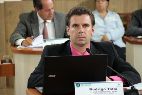 #PraCegoVer: Foto mostra o vereador Rodrigo Toloi (DEM) sentado em seu lugar no plenário, prestando atenção na sessão ordinária.