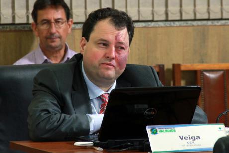 #PraCegoVer: Foto mostra o vereador Veiga (DEM) sentado em seu lugar no plenário, prestando atenção na sessão ordinária.