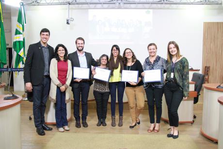 #PraCegoVer: Foto mostra palestrantes da Semana da Inclusão recebendo certificados de agradecimento.