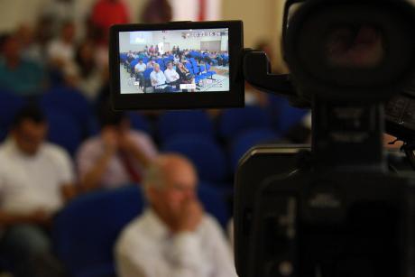 #PraCegoVer: Imagem mostra visor de uma Câmera digital mostrando pessoas sentadas no auditório da Câmara acompanhando a sessão. Ao redor do visor, pode-se ver as mesmas pessoas, desfocadas. 