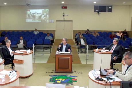 #PraCegoVer: Foto mostra o plenário, com o ex-prefeito Clayton Machado sentado no centro. Ele discursa no microfone, virado para os vereadores.