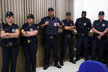 #PraCegoVer: Foto mostra seis guardas municipais uniformizados acompanhando a discussão do projeto no plenário da Câmara. São duas guardas femininas na ponta esquerda e quatro guardas masculinos à direita.