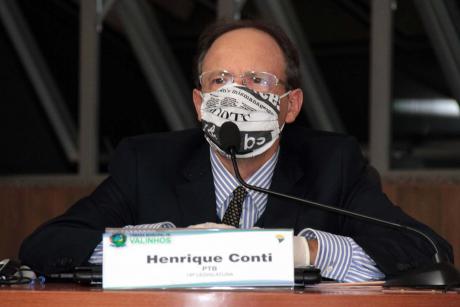 #PraCegoVer: Vereador Henrique Conti, usando uma máscara, acompanha a sessão de sua tribuna 